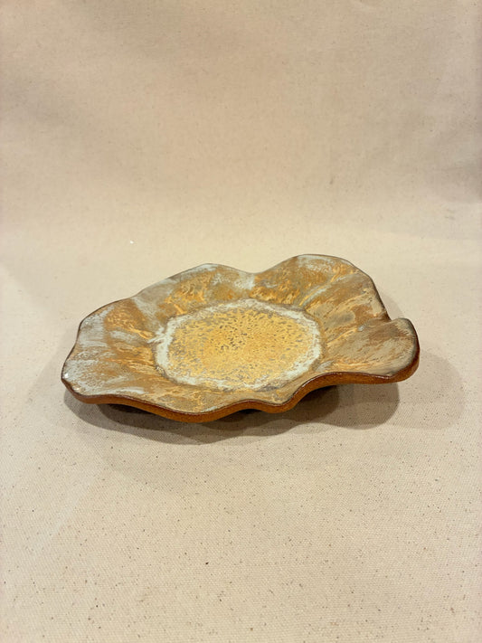 Decorative ceramic dish with a textured surface on a beige background